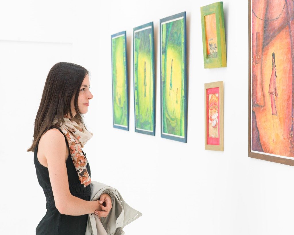 Woman looking at art pieces in gallery
