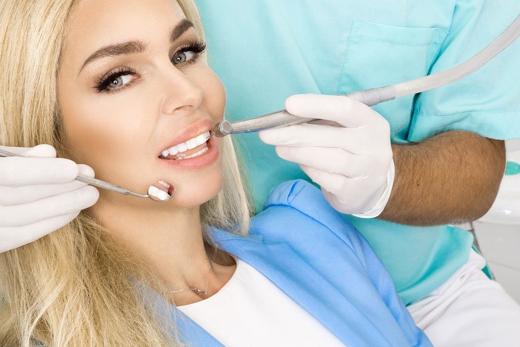 Woman having her teeth cleaned by the dentist