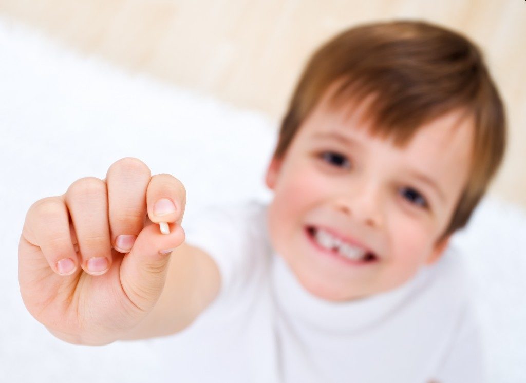 Child holding his tooth