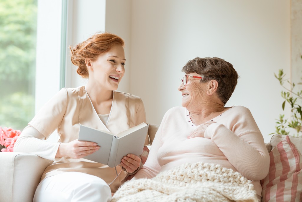 person reading a book to an elderly